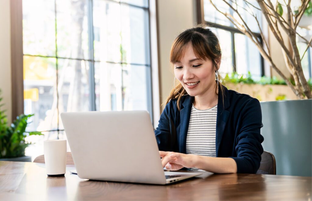 Person smiling in front of laptop